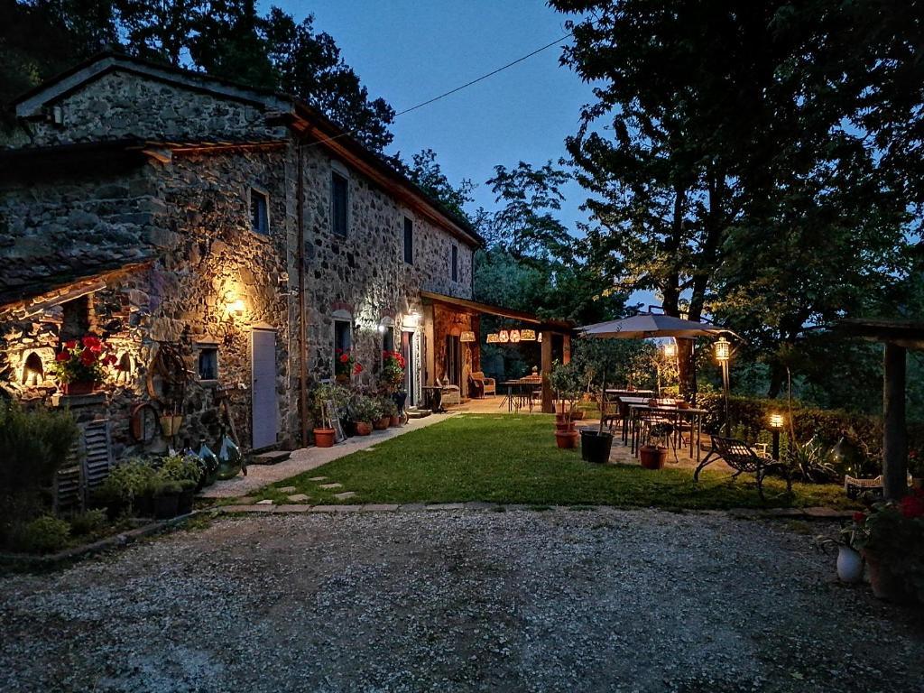 un edificio de piedra con una mesa y una sombrilla en Agriturismo Tananei, en Marliana