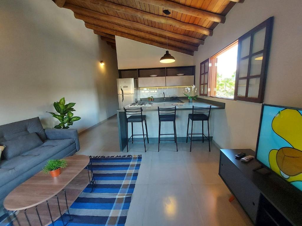 sala de estar con sofá y TV y cocina en Mamanguá - Apto c/ piscina, 50mts da praia, cozinha, churrasqueira, ar con, WiFi, netflix, garagem, en Paraty