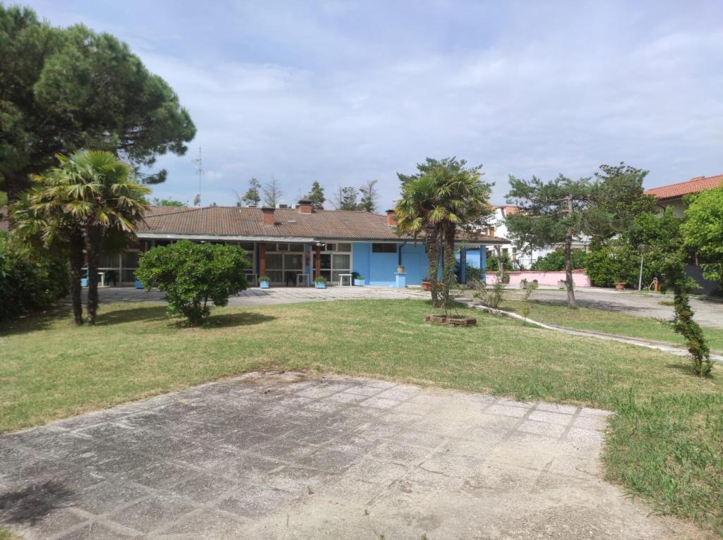 a house with palm trees in front of it at Duna camere con bagno in Lido Adriano