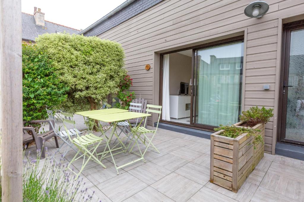 d'une terrasse avec une table et des chaises sur le côté de la maison. dans l'établissement Kerael, à Perros-Guirec