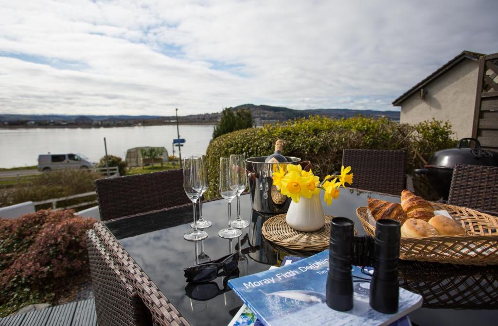 un tavolo con bicchieri da vino e pane sul balcone di Fishermans a Inverness