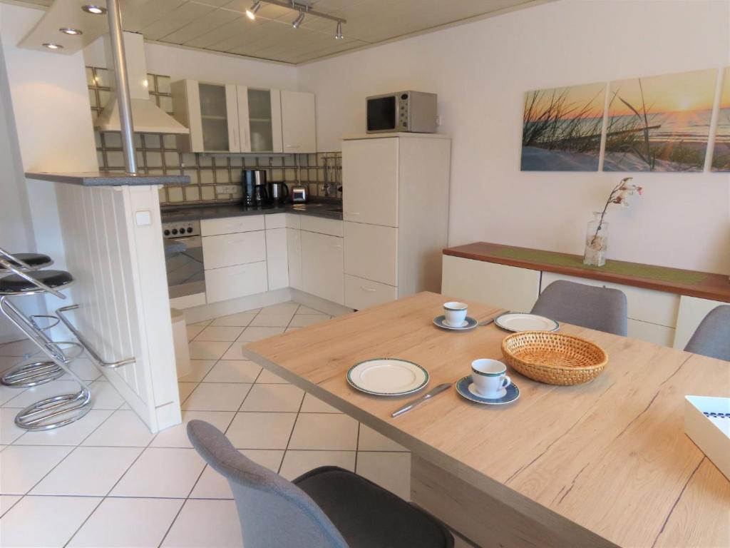 eine Küche und ein Esszimmer mit einem Holztisch und Stühlen in der Unterkunft Ferienwohnung Ossiander in Uhldingen-Mühlhofen