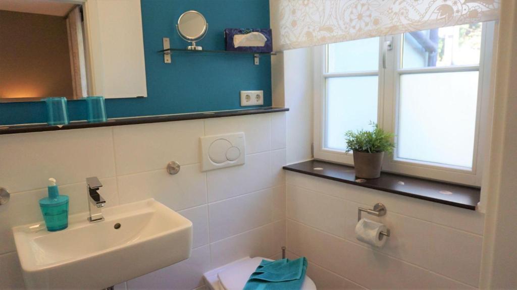 a bathroom with a sink and a toilet and a window at Ferienwohnungen Lebenswert Ferienwohnung Lebenswert I in Meersburg