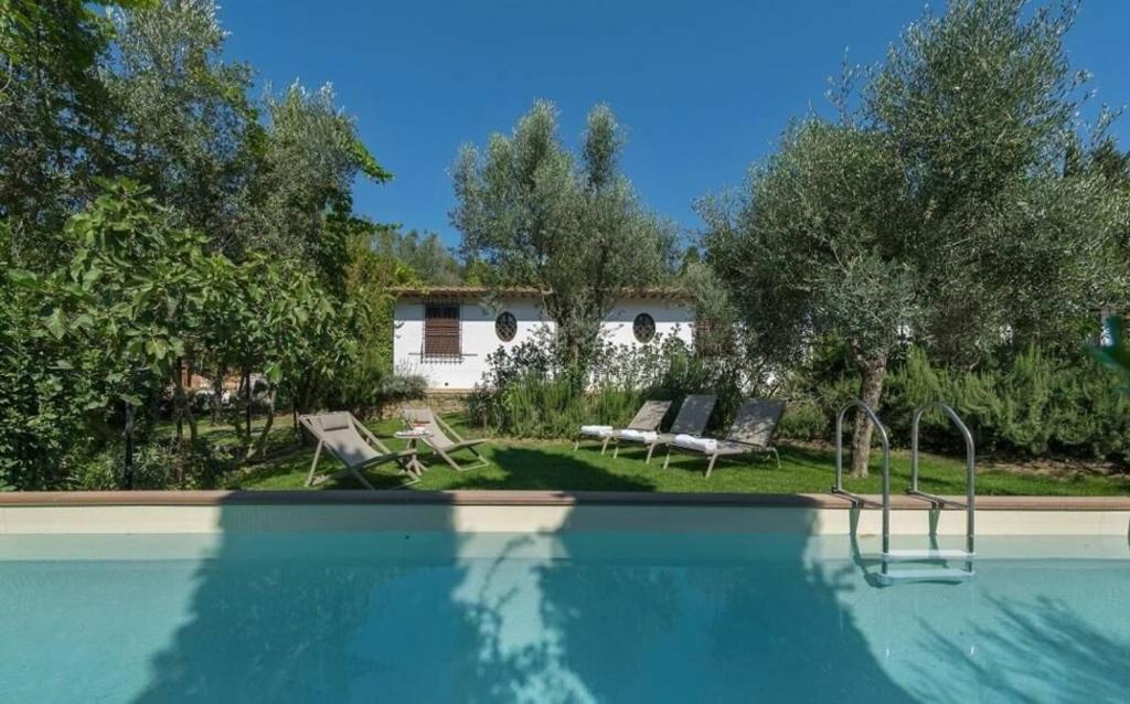 a swimming pool with two chairs and a house at Villa Galli in Calenzano