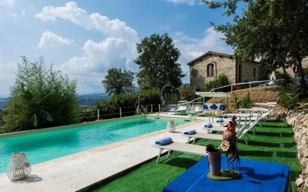 uma piscina com bancos e uma casa em Villa Due Case em San Cristoforo a Perticaia