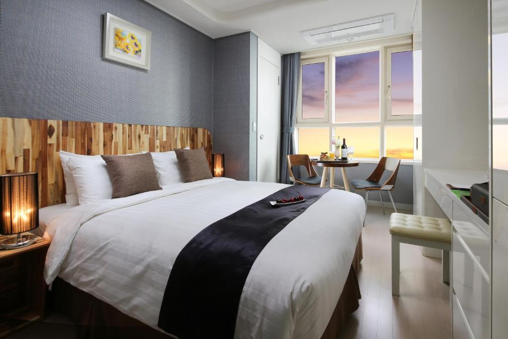 首爾的住宿－愛威爾8服務公寓酒店，一间卧室配有一张大床和一张桌子
