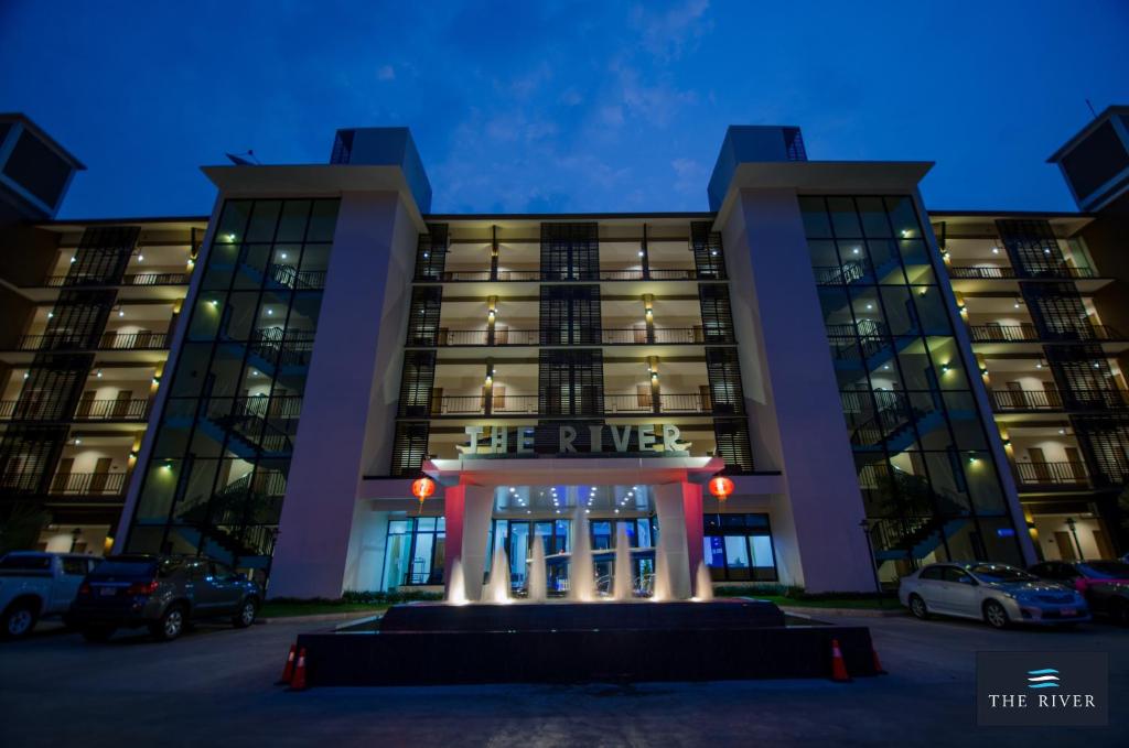 a building with a sign that reads the river at The River Hotel in Nakhon Phanom