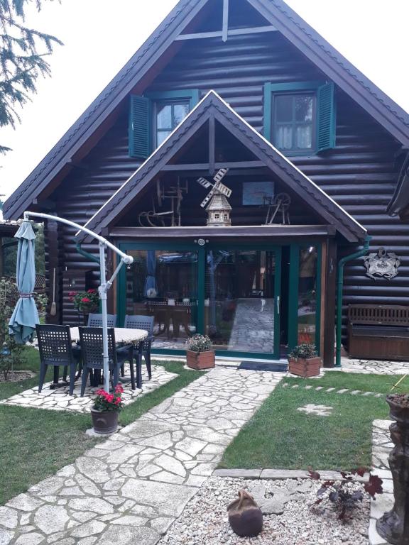 a house with a table and chairs in front of it at Meseház Apartman in Zalalövő