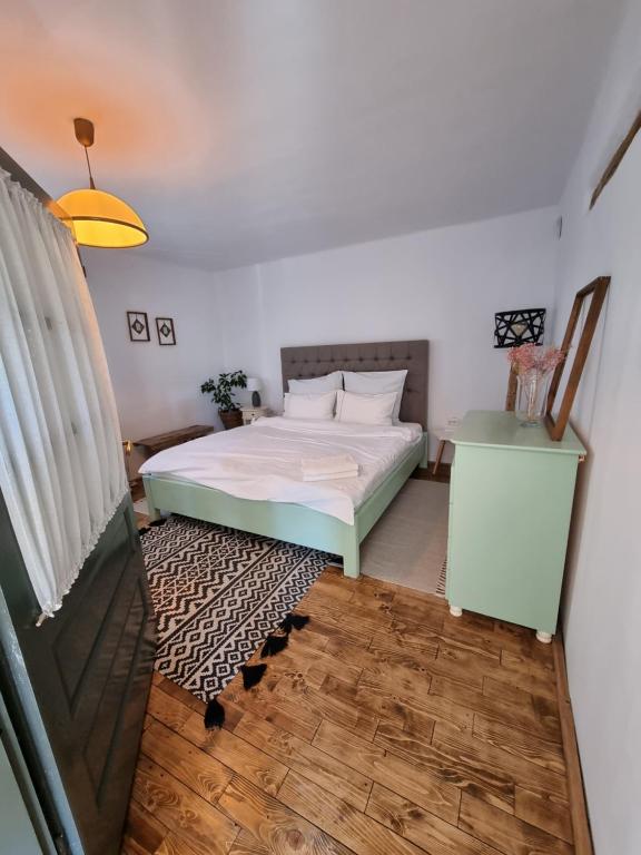 a small bedroom with a bed and a table at Guest House Victoria in Galda de Jos