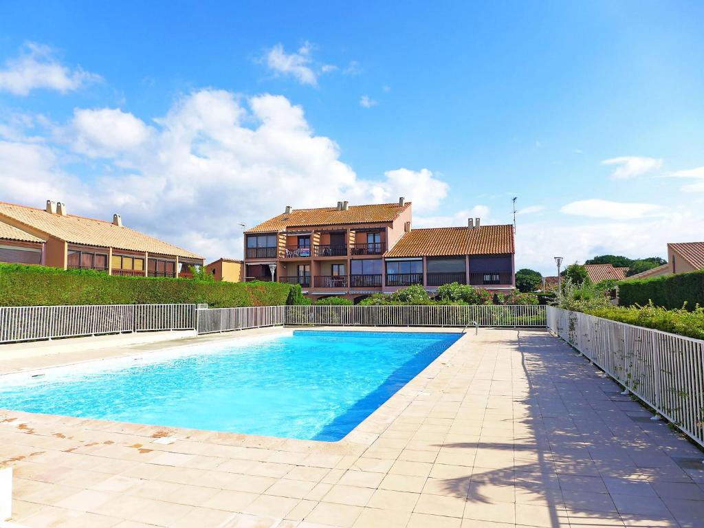 a swimming pool in front of a house at Holiday Home Les Amandines-3 by Interhome in Gruissan