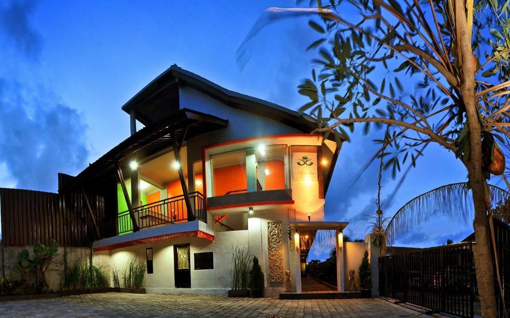 a house with a lit up facade at night at Amerta Home Stay Bali in Denpasar