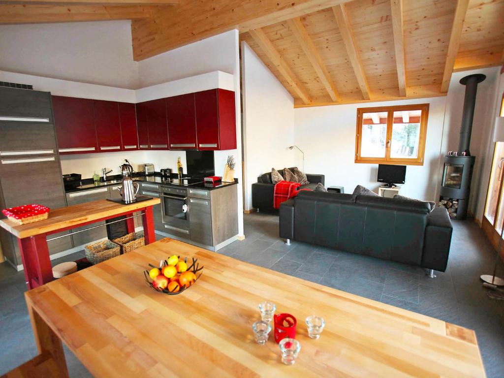 eine Küche und ein Wohnzimmer mit einem Holztisch in der Unterkunft Chalet Chloé by Interhome in Ovronnaz