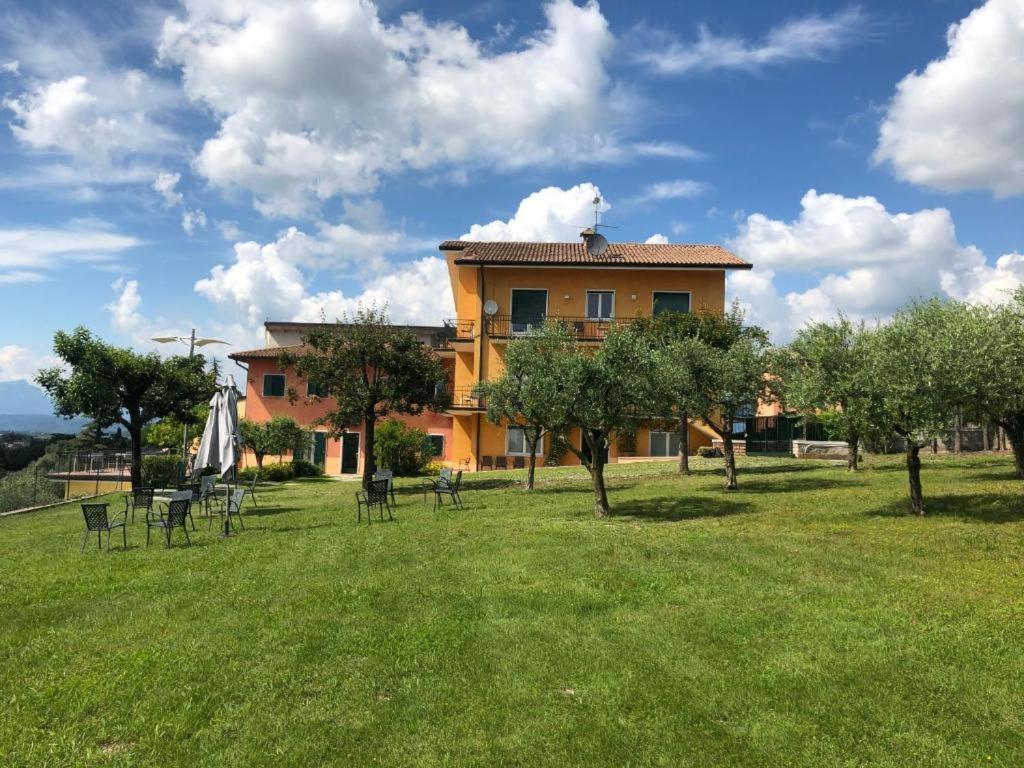 a building in a field with chairs and trees at Nice apartment lake view & free parking in Pastrengo