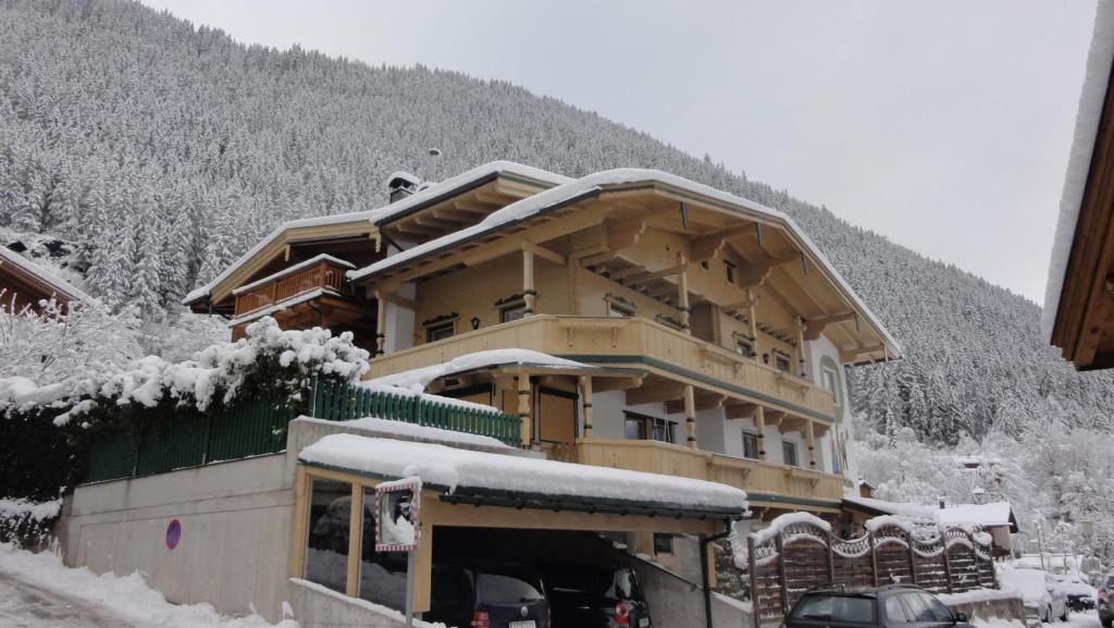 um grande edifício com neve em cima em Ferienwohnungen am Riedanger em Mayrhofen