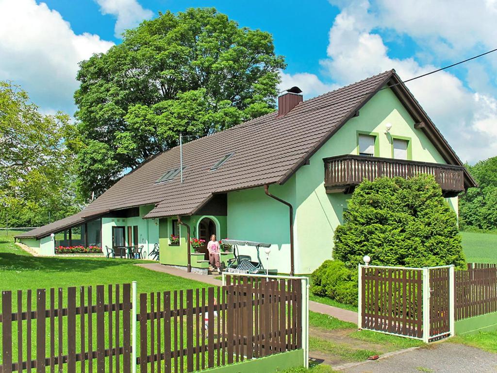 uma casa verde e branca com uma cerca de madeira em Holiday Home Haus Polivka - HUR100 by Interhome em Třebíšov