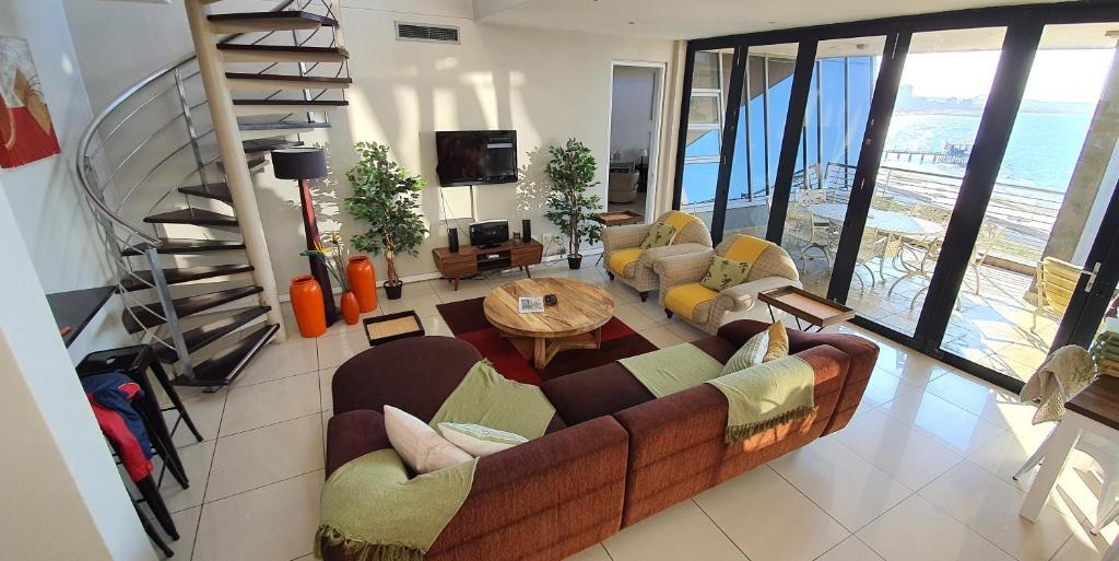 a living room with a couch and a table at Stay at The Point - Prestigious Prominent Penthouse in Durban