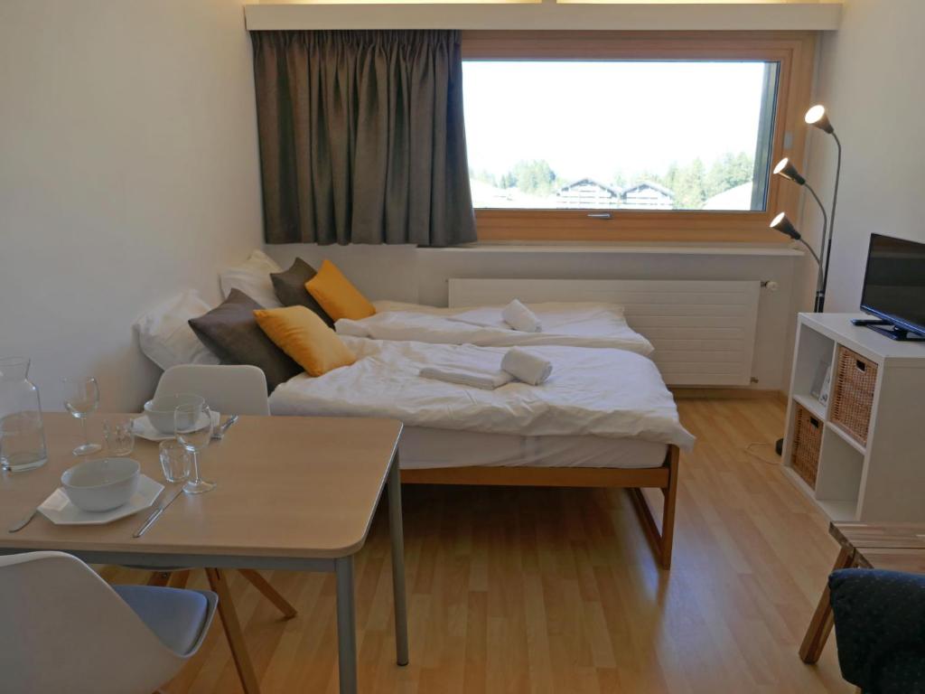 ein Wohnzimmer mit einem Bett und einem Tisch in der Unterkunft Apartment Rosablanche B76 by Interhome in Siviez