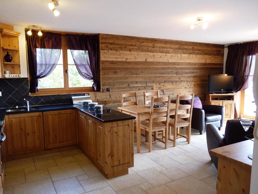 una cucina e una sala da pranzo con tavolo e sedie di Apartment Ardève No 11 by Interhome a Ovronnaz