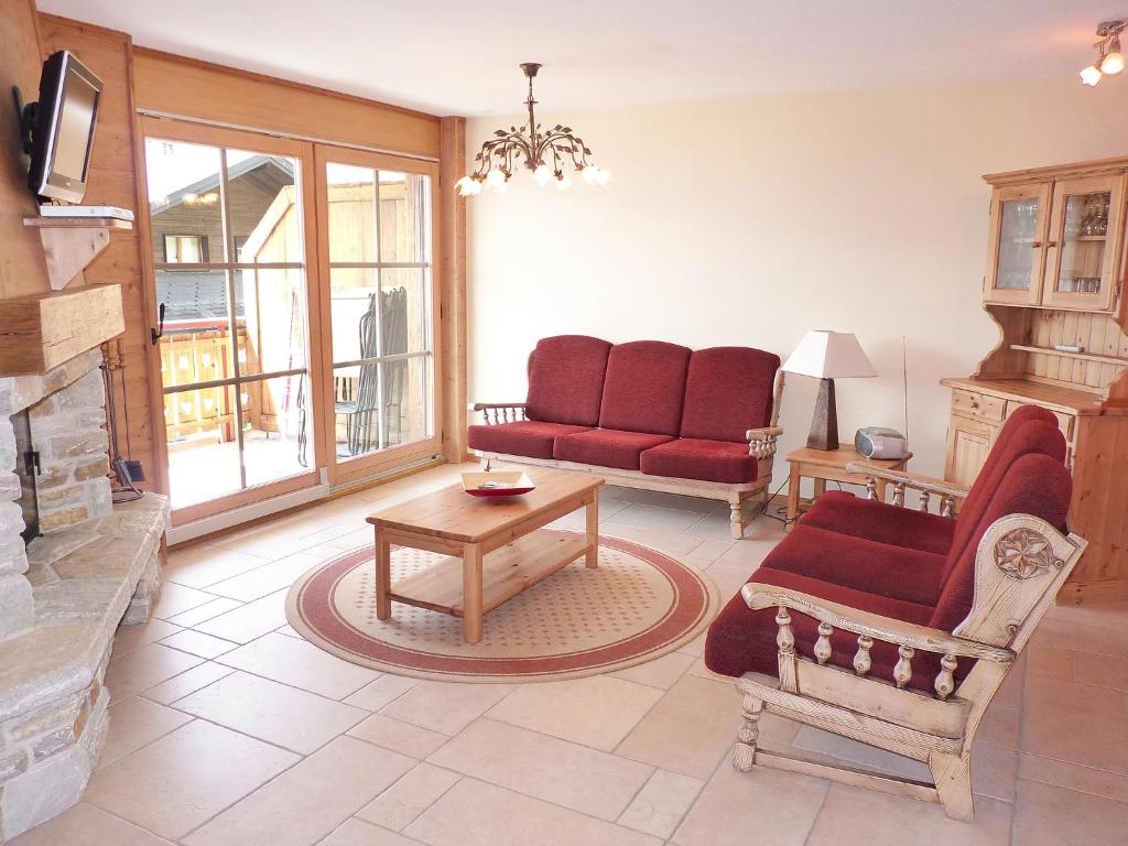 オヴロナにあるApartment Ardève No 7 by Interhomeのリビングルーム(赤い家具、暖炉付)