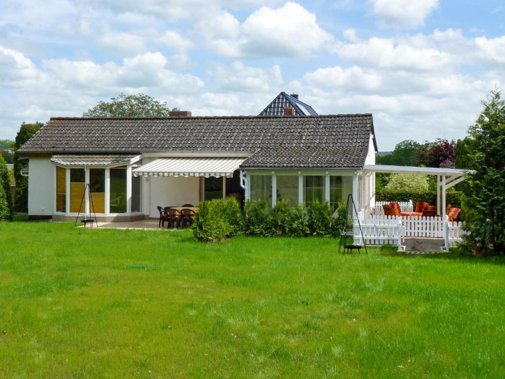 ein weißes Haus mit einer Veranda und einer Liegewiese in der Unterkunft Holiday Home Alexorella by Interhome in Godern