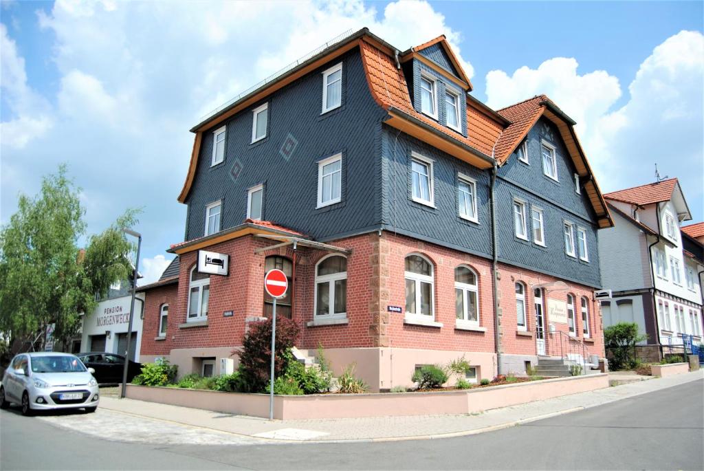 une grande maison avec un toit noir dans une rue dans l'établissement Pension Morgenweck, à Bad Salzungen