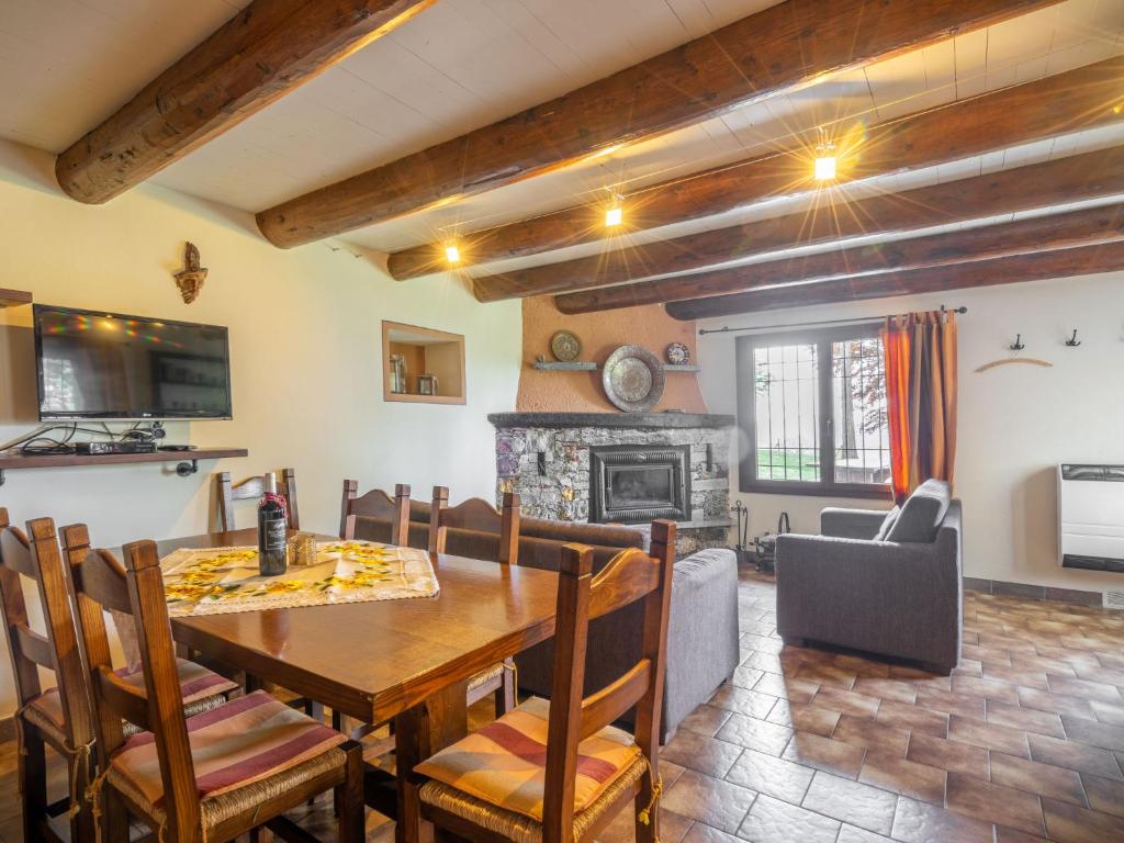 jadalnia ze stołem i krzesłami oraz kominkiem w obiekcie Holiday Home Baita Nini by Interhome w mieście Trarego