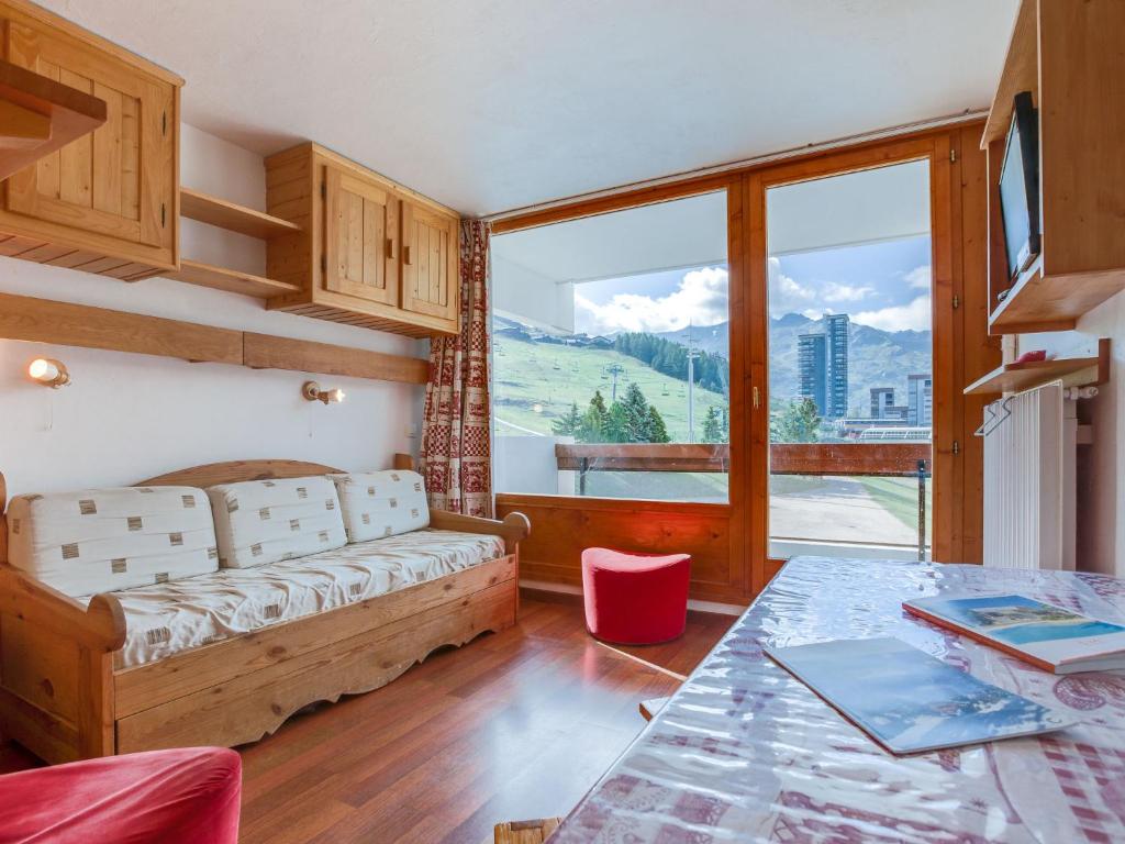 a living room with a couch and a large window at Apartment Chavière-5 by Interhome in Les Menuires