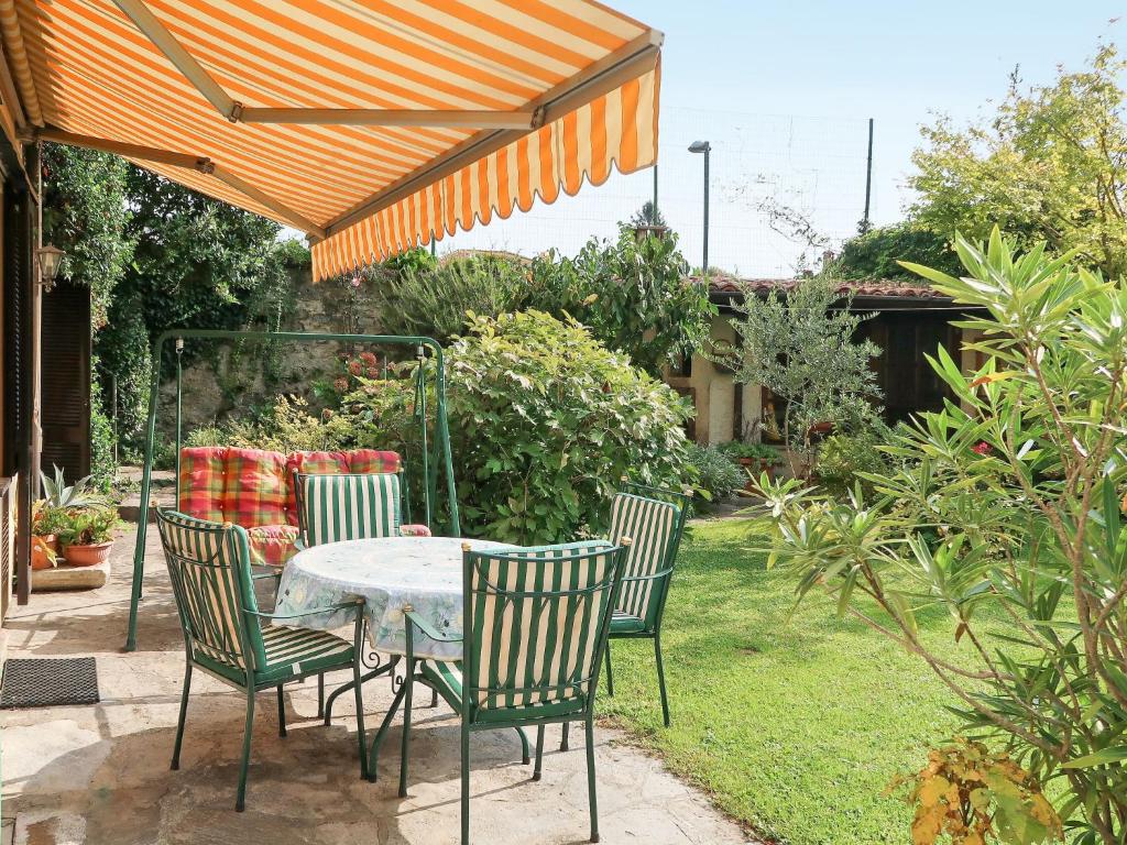 ドンゴにあるApartment Il Giardino by Interhomeの庭の傘下のテーブルと椅子