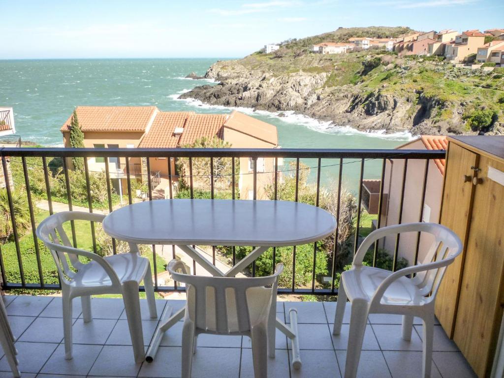 a table and chairs on a balcony with the ocean at Apartment Les Roches Bleues-5 by Interhome in Collioure