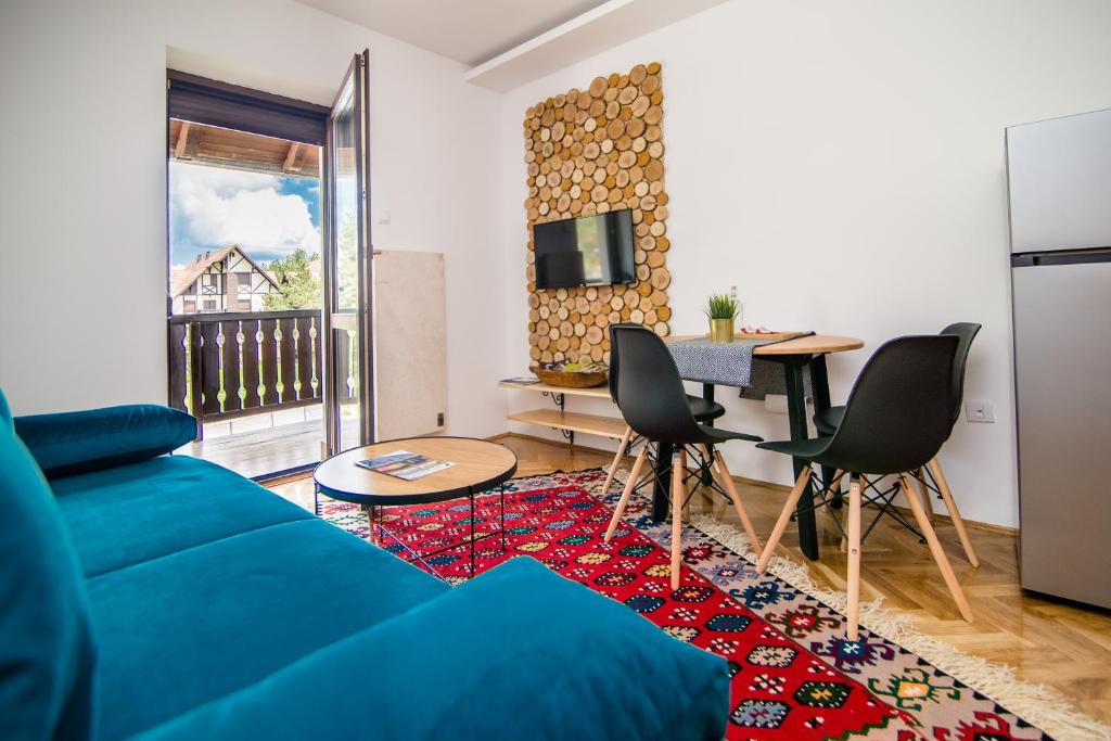 a living room with a blue couch and a table at Apartment Sunčana dolina in Zlatibor