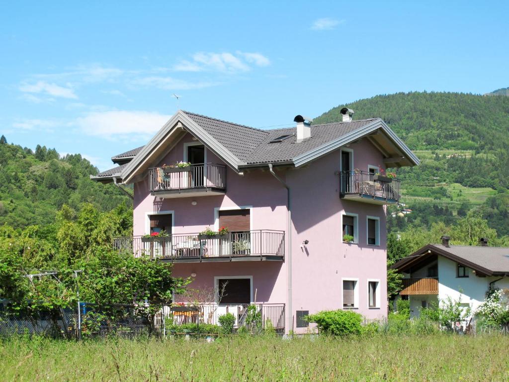 een roze huis met balkons op een heuvel bij Apartment Deval-1 by Interhome in Calceranica al Lago
