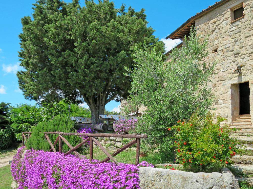 ogród z fioletowymi kwiatami i drewnianym płotem w obiekcie Apartment Fonte - Borgo la Civitella by Interhome w mieście Roccastrada