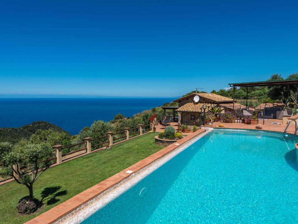 a swimming pool with the ocean in the background at Villa Ricali by Interhome in Porto Santo Stefano