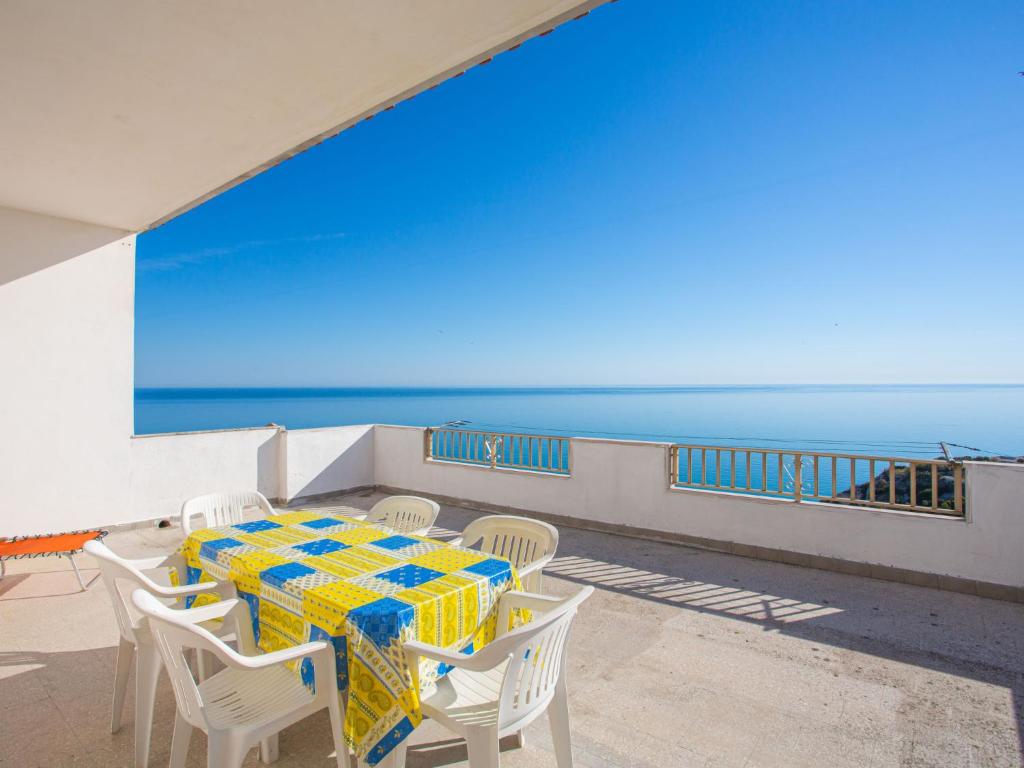 een tafel en stoelen op een balkon met uitzicht op de oceaan bij Apartment Villa Teresa by Interhome in Peschici