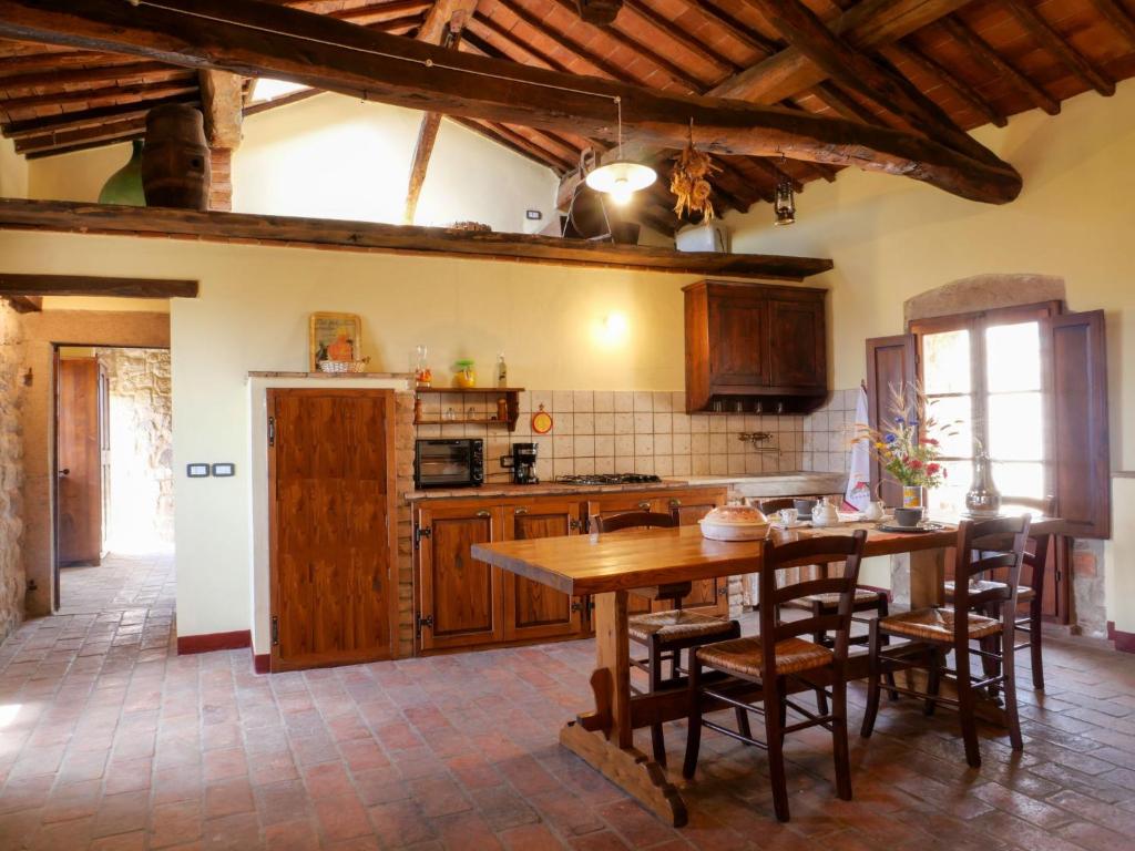 duża kuchnia z drewnianym stołem i krzesłami w obiekcie Apartment Torretta - Borgo la Civitella by Interhome w mieście Roccastrada