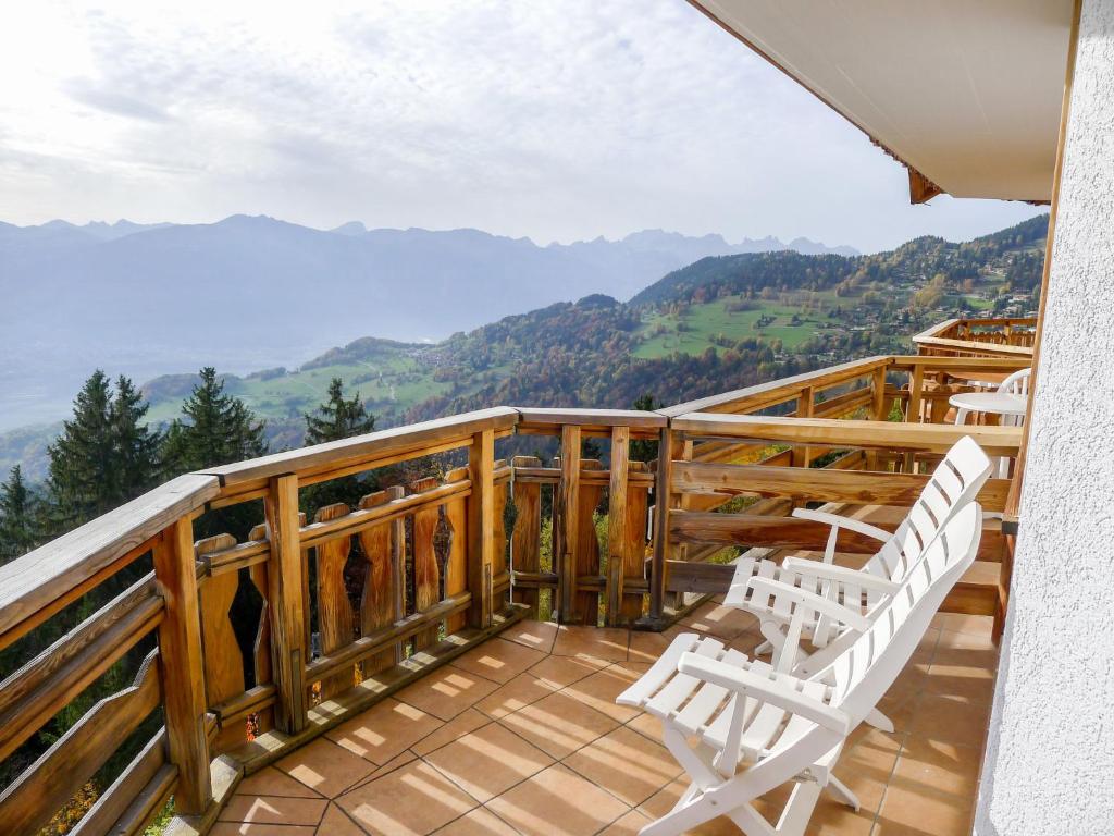 a balcony with two chairs and a view of mountains at Apartment Le Bristol C54 by Interhome in Villars-sur-Ollon