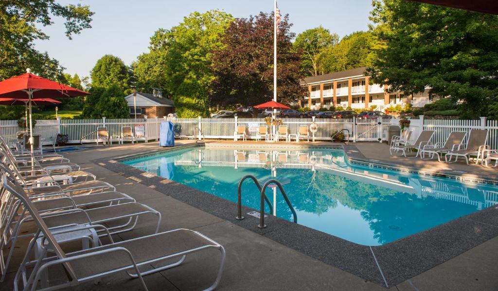 a large swimming pool with chairs and umbrellas at Ogunquit The Milestone Inn in Ogunquit