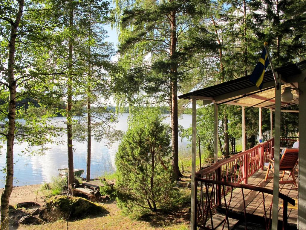 a house with a deck next to a lake at Chalet Älgnäs - HSL040 by Interhome in Stråtjära