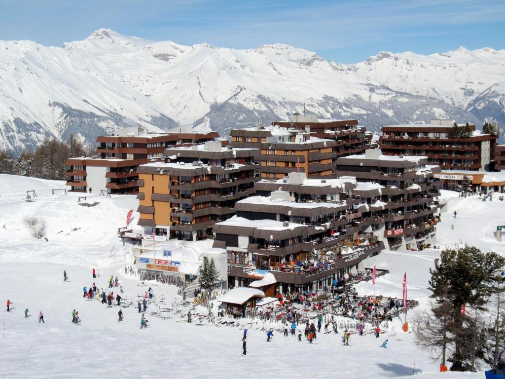 un grupo de personas en la nieve frente a un hotel en Apartment Résidence Essert-25 by Interhome, en Les Collons