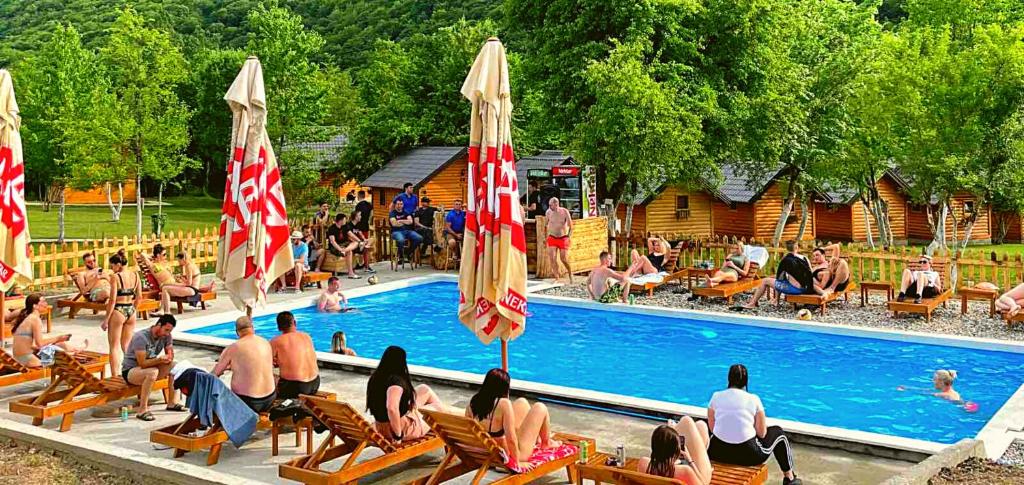 un grupo de personas sentadas en sillas cerca de una piscina en Rafting centar RT en Foča