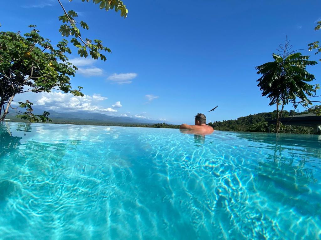 a man in the water in a infinity pool at Casa Libertinn in Manuel Antonio