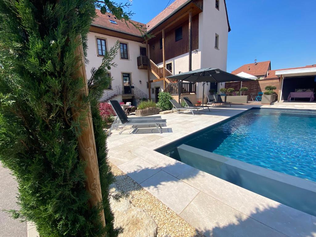 a swimming pool in front of a house at Chambres d&#39;hôtes - L&#39;Ecurie Obernai in Obernai