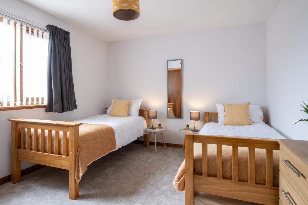 a bedroom with two beds and a window at Bowmore in Lossiemouth