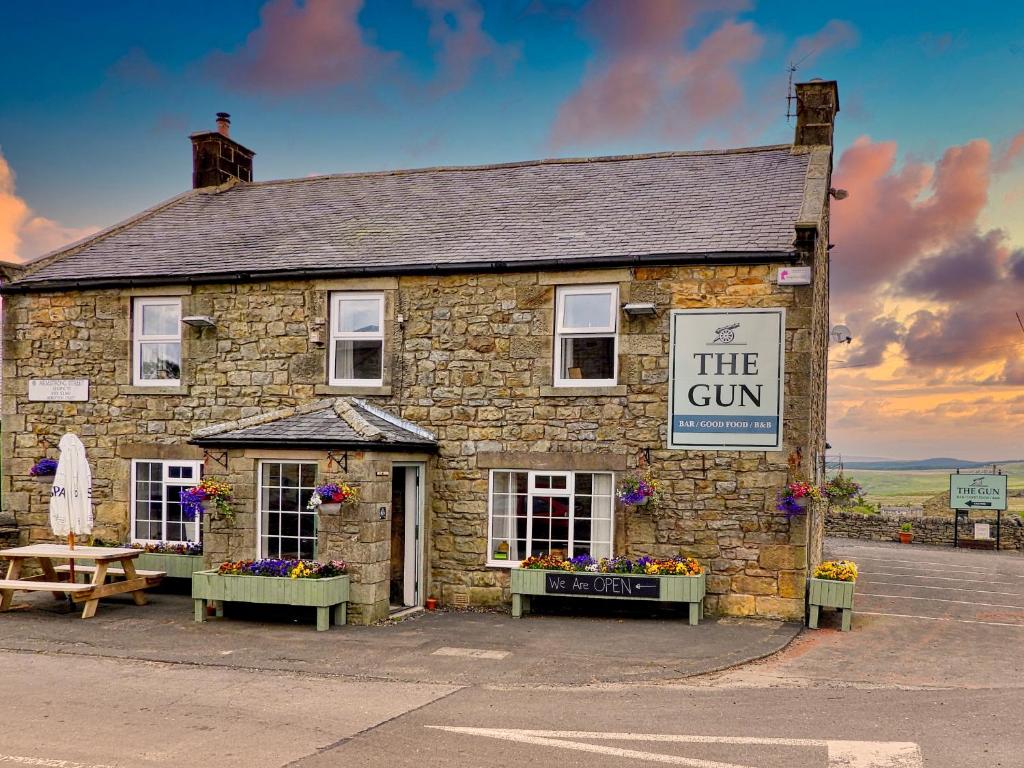 un edificio de piedra con un cartel que dice el arma en The Gun at Ridsdale, en Ridsdale