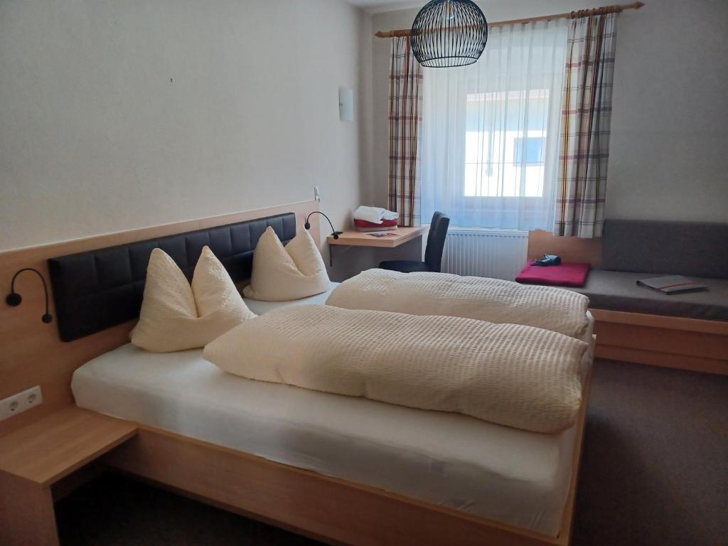 a hotel room with two beds and a couch at Hotel Garni Löwen in Silz