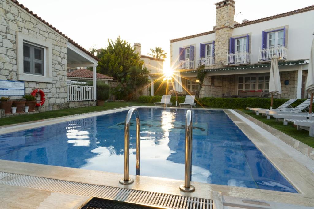 a swimming pool in front of a house at Panda Alacati Hotel in Alaçatı