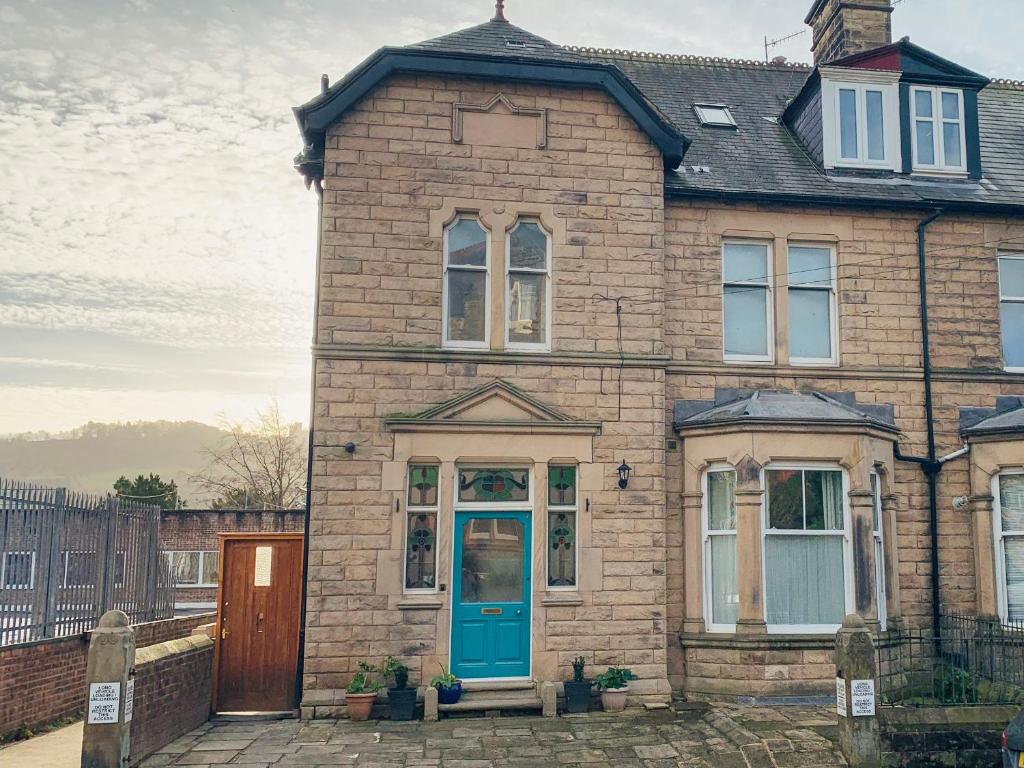 an old brick house with a blue door at Arlington House in Matlock