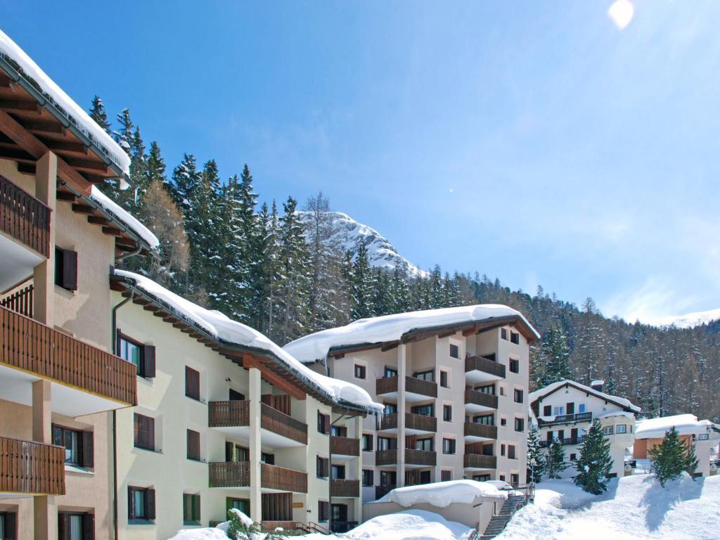 ein schneebedecktes Gebäude mit einem Berg im Hintergrund in der Unterkunft Apartment Residenza Chesa Margun 67-2 by Interhome in Surlej