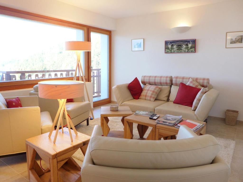 ein Wohnzimmer mit einem Sofa und einem Tisch in der Unterkunft Apartment Les Aiguilles Vertes by Interhome in Crans-Montana
