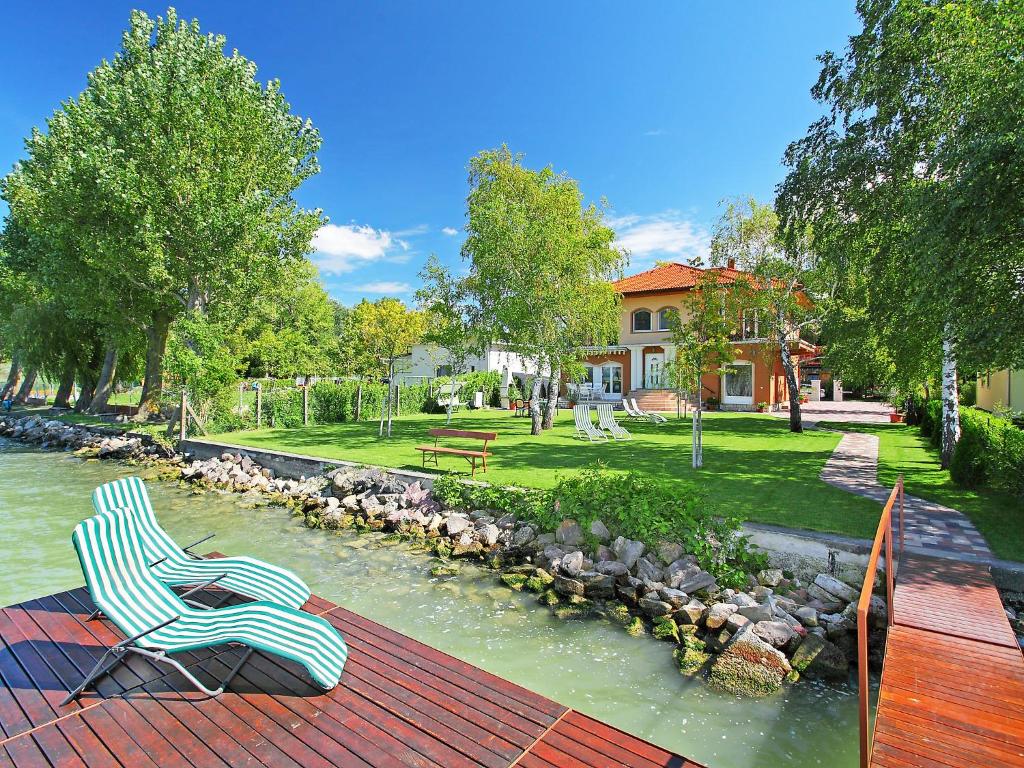 a plastic chair sitting on a deck next to a river at Apartment Lakefront 1 by Interhome in Balatonlelle